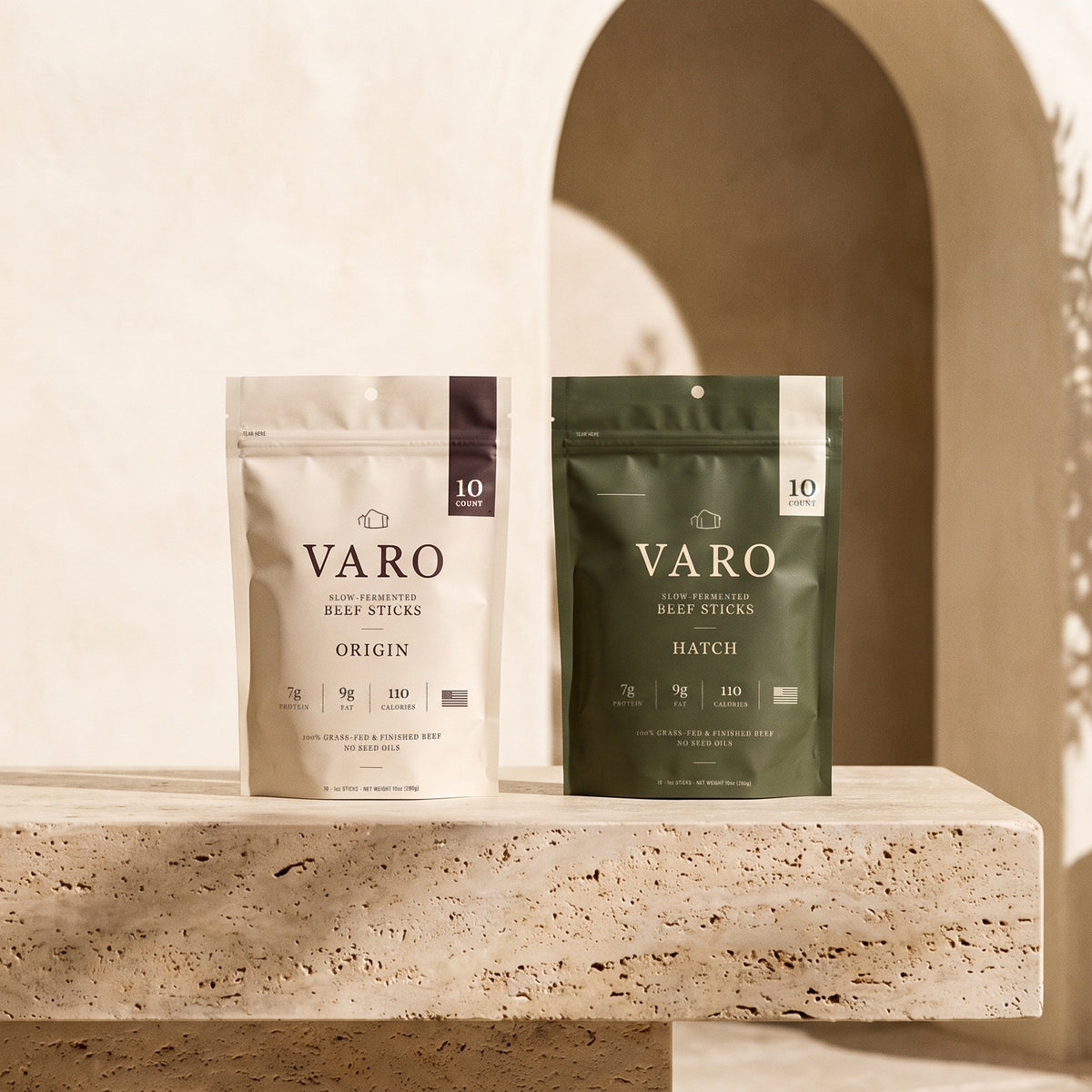 ORIGIN and HATCH bags of VARO slow-fermented beef sticks on a sunlit travertine ledge